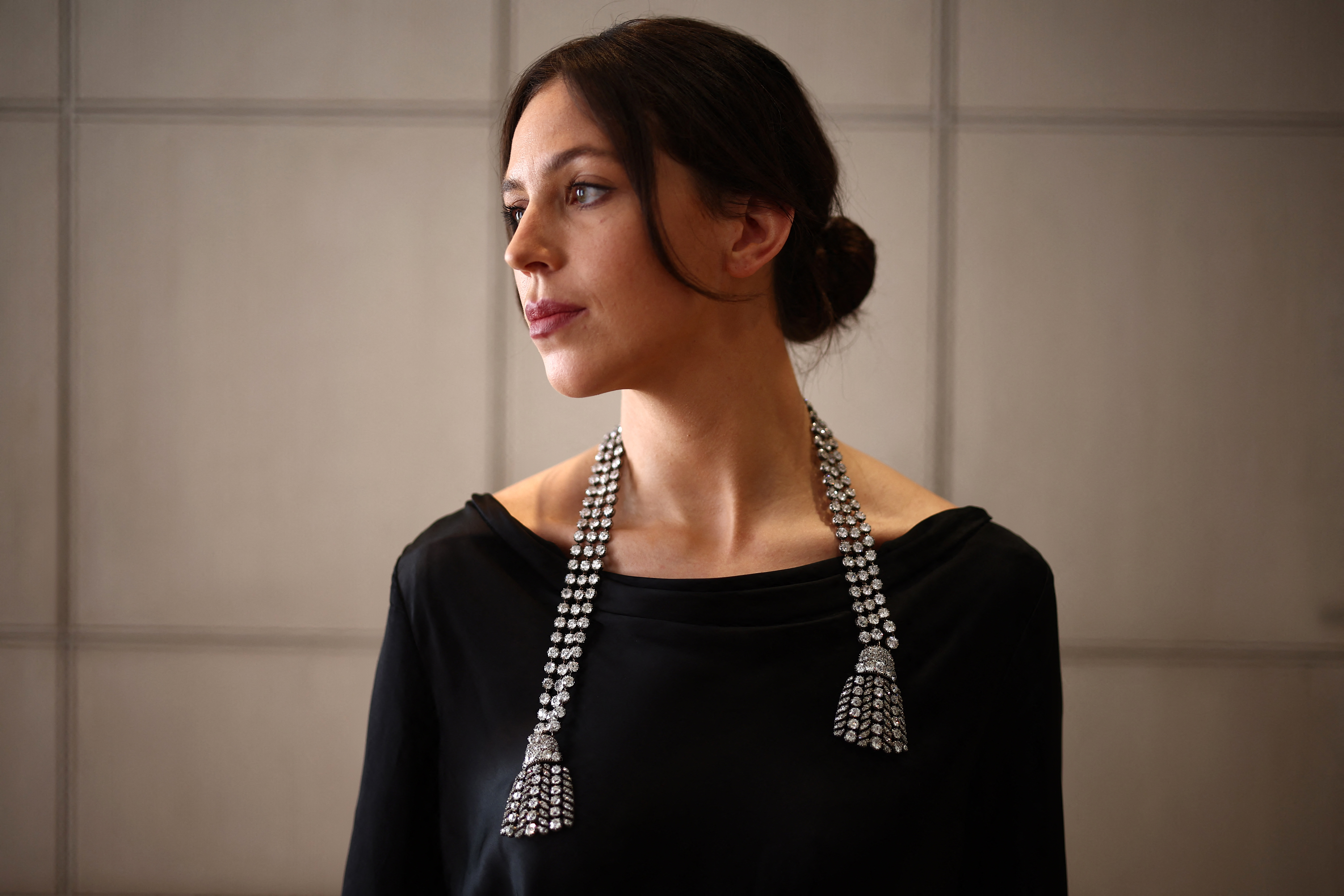 A gallery assistant poses wearing an 18th century diamond jewel necklace.