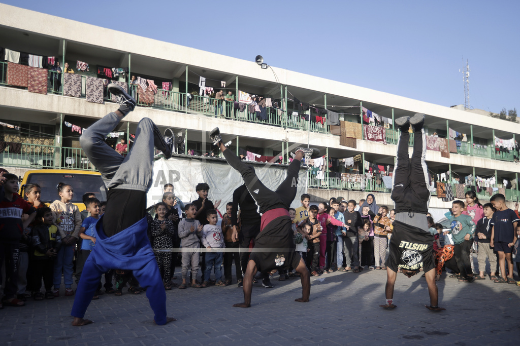 Palestinians present an entertainment performance for displaced children sheltering at a UN school
