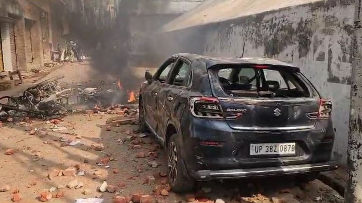 A view of a vehicle set ablaze during clashes in Sambhal, Uttar Pradesh