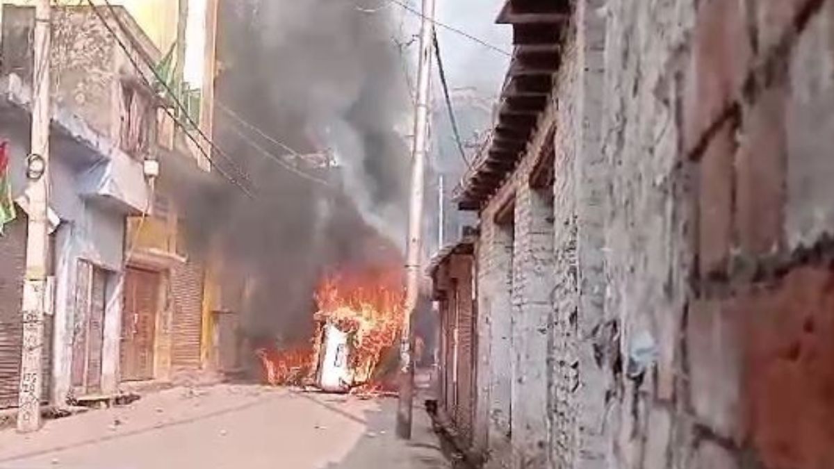 A view of a vehicle set ablaze during clashes in Sambhal, Uttar Pradesh