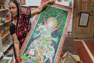 An artist with her pattachitra art