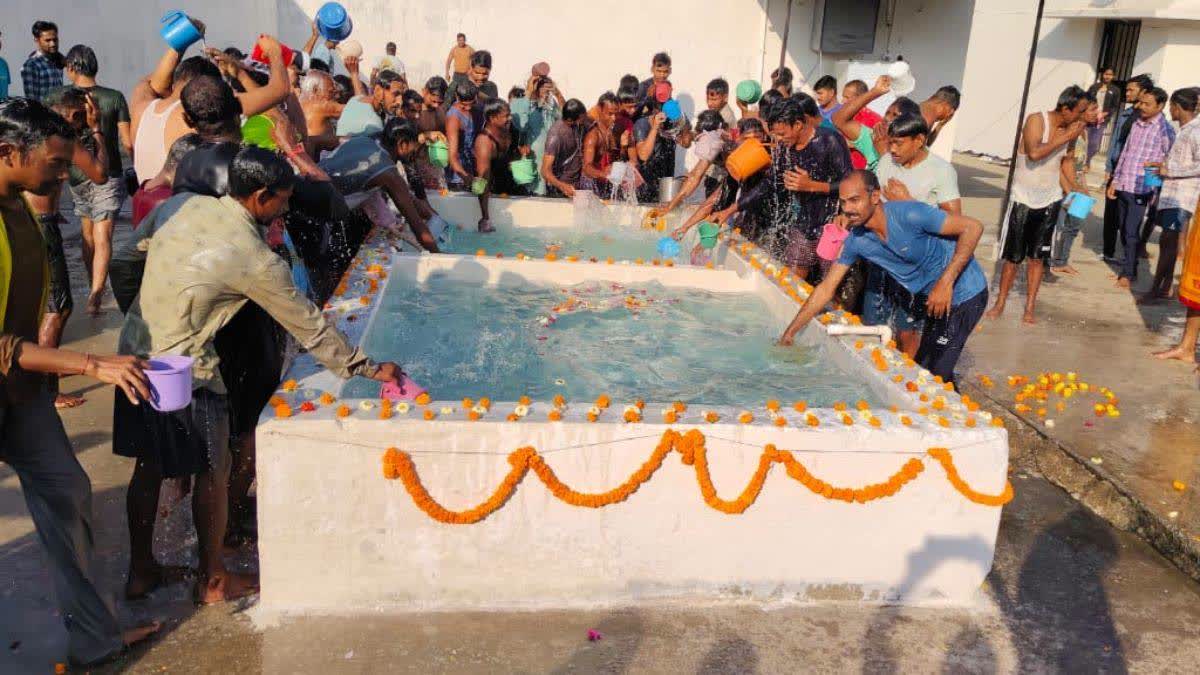 Inmates take bath in an artificial pond.