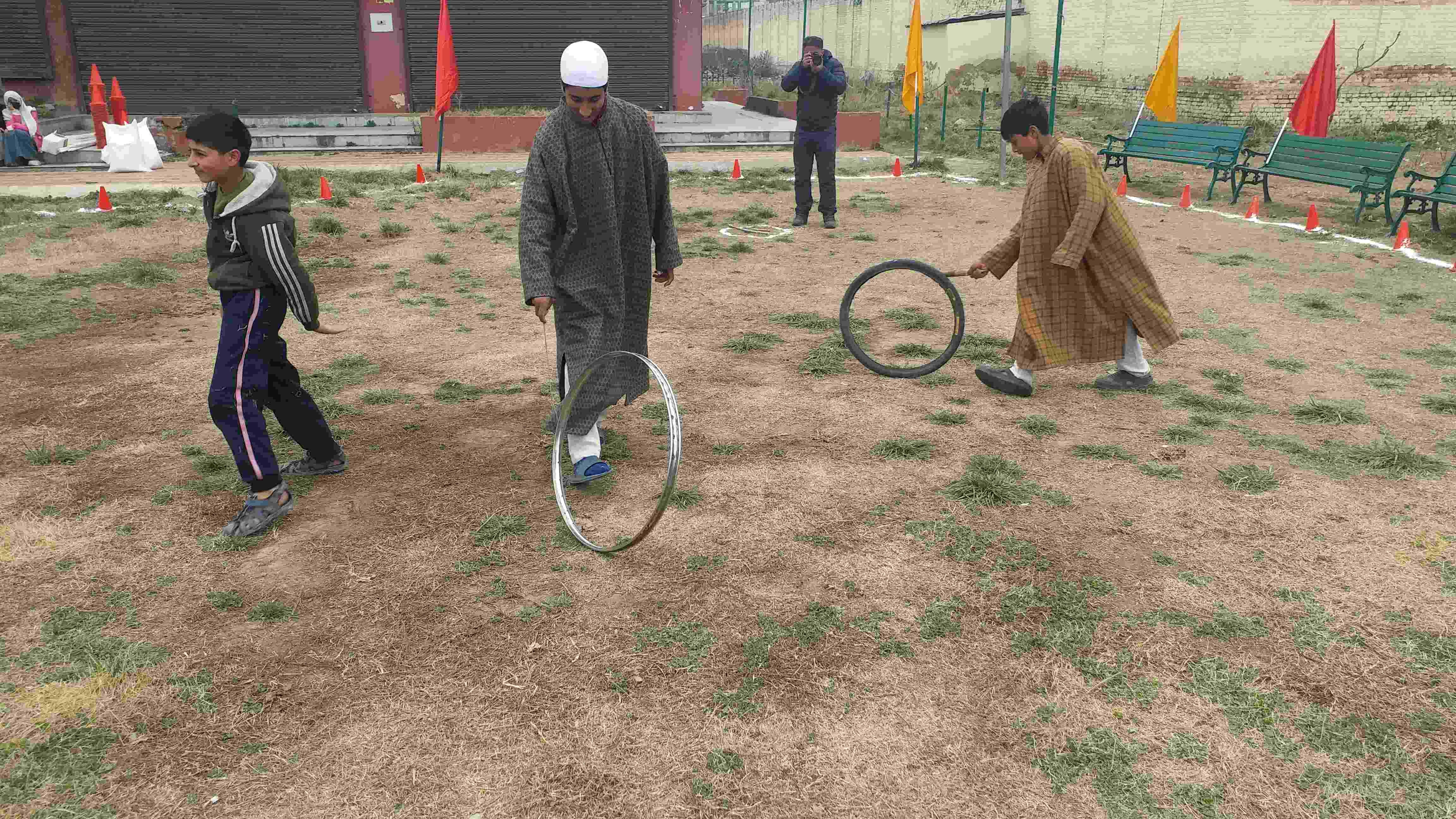 کشمیر ہاٹ نمائش کے مصنوعی گاؤں میں ٹائر اور سائیکل کے رم سے کھیلتے بچے