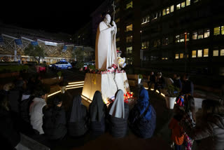 People pray for Pope Francis in front of the Agostino Gemelli Polyclinic, in Rome, Sunday, Feb. 23, 2025, where the Pontiff is hospitalized since Friday, Feb. 14.