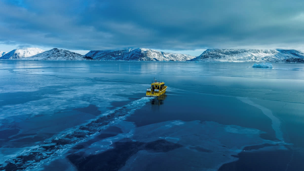 A boat rides though a frozen sea inlet outside of Nuuk, Greenland, March 6, 2025.