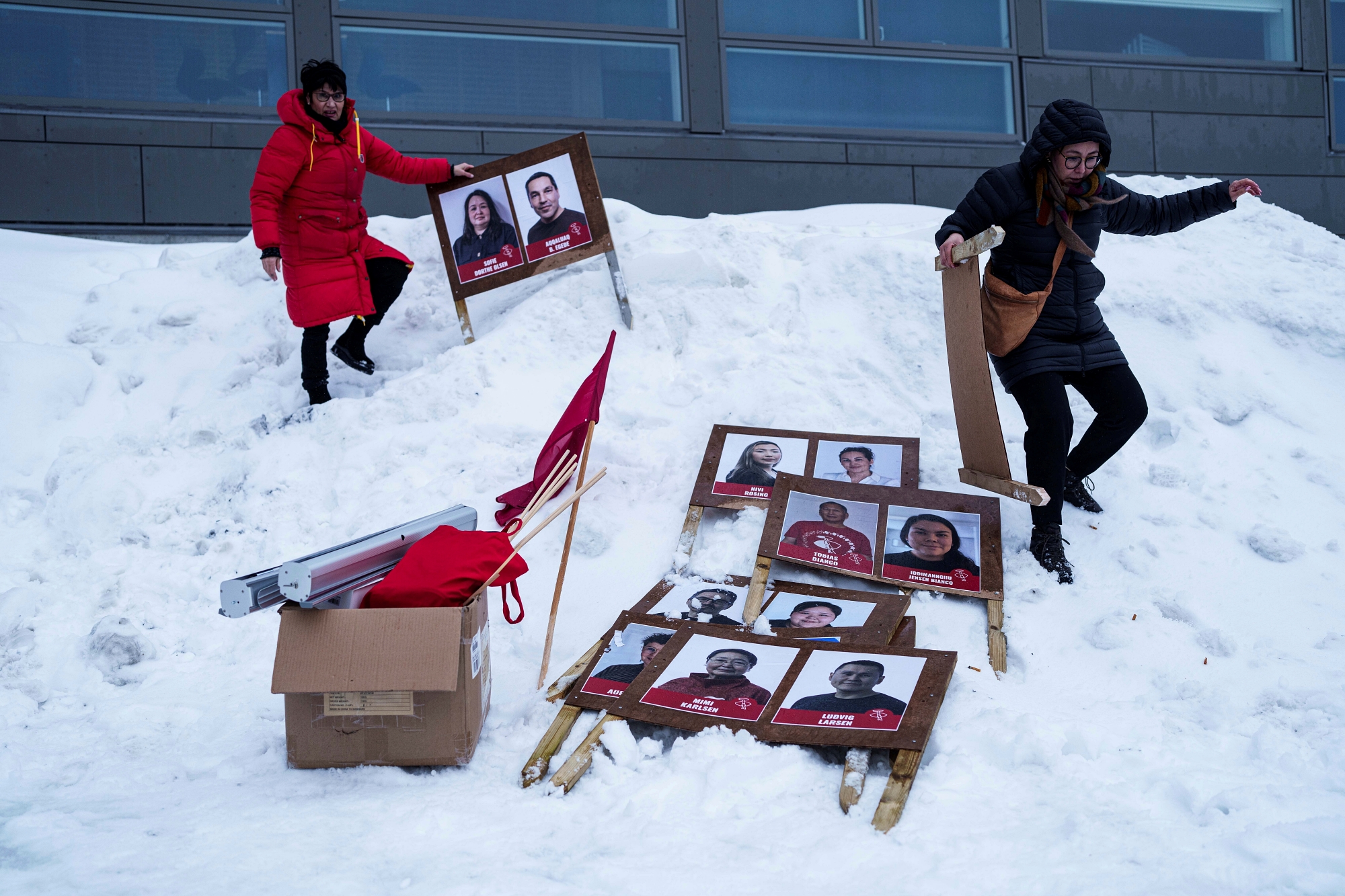 Women carry political placards for the upcoming elections in Nuuk, Greenland, Saturday, March 8, 2025.