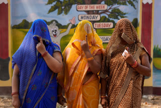 Women voters show their index fingers marked with an indelible ink after casting their vote in the sixth round of polling in India's national election in Prayagraj, India, Saturday, May 25, 2024.