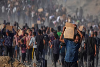 Palestinians carry sacks and boxes of food and humanitarian aid unloaded from a World Food Program convoy that had been heading to Gaza City, in the northern Gaza Strip, Monday, June 16, 2025.