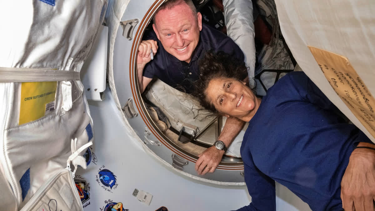 Boeing Crew Flight Test astronauts Butch Wilmore, left, and Suni Williams pose for a portrait inside the vestibule between the forward port on the International Space Station's Harmony module and Boeing's Starliner spacecraft on June 13, 2024.