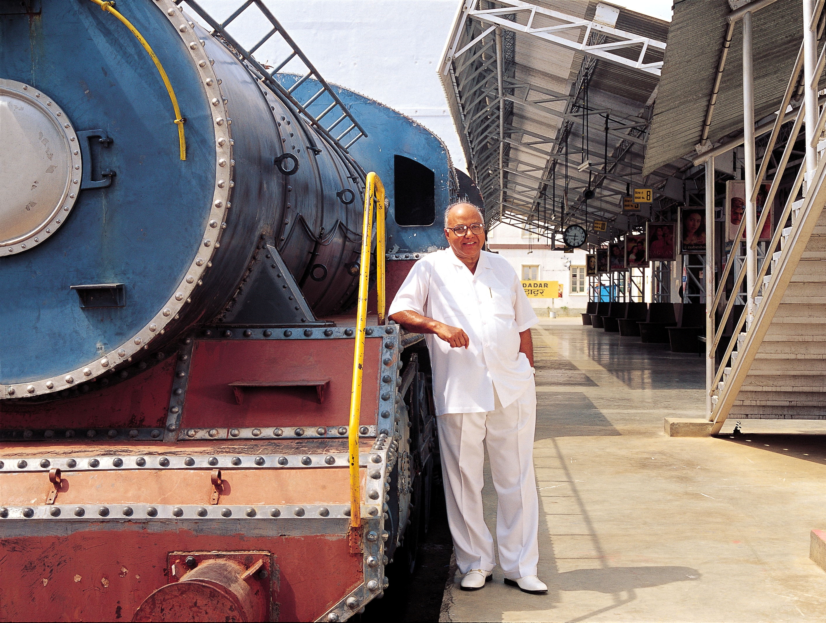 Ramoji Rao standing near Train engine set at Ramoji Film City