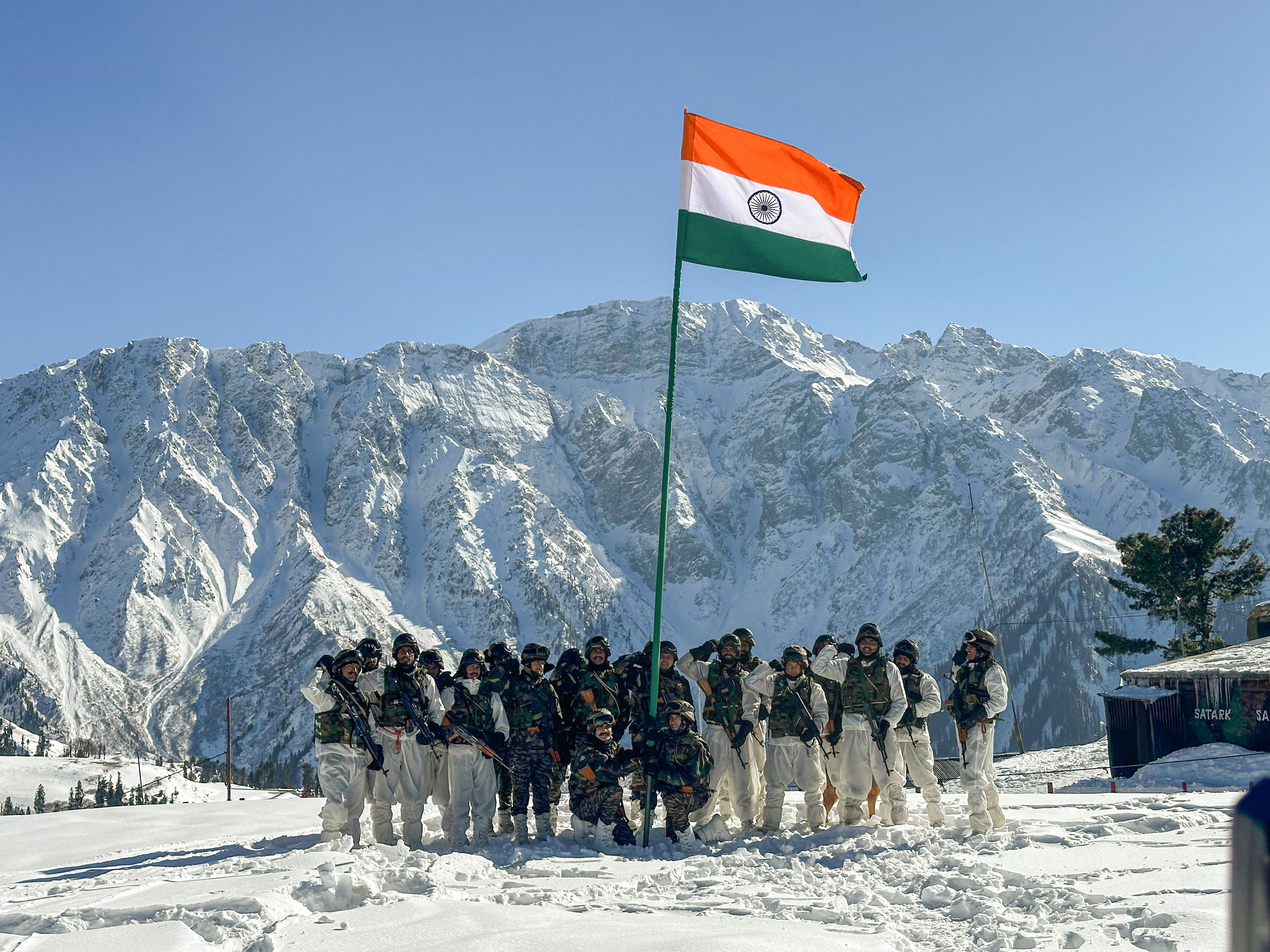 Army personnel pose for a picture with the National Flag along the Line of Control (LoC) amid sub-zero temperatures ahead of Republic Day, in Kupwara on Friday.