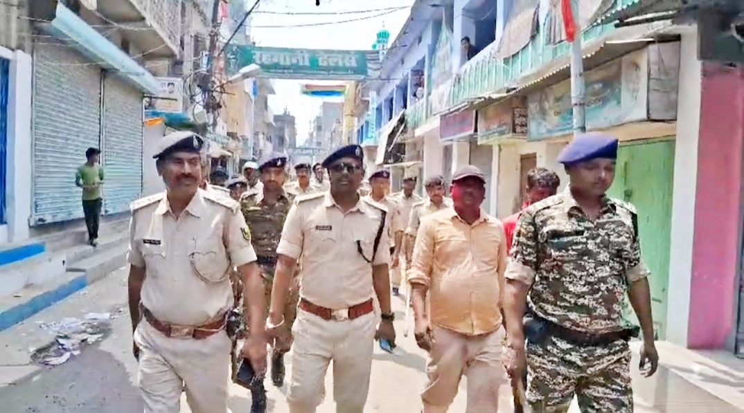 इलाके में फ्लैग मार्च निकालती पुलिस.