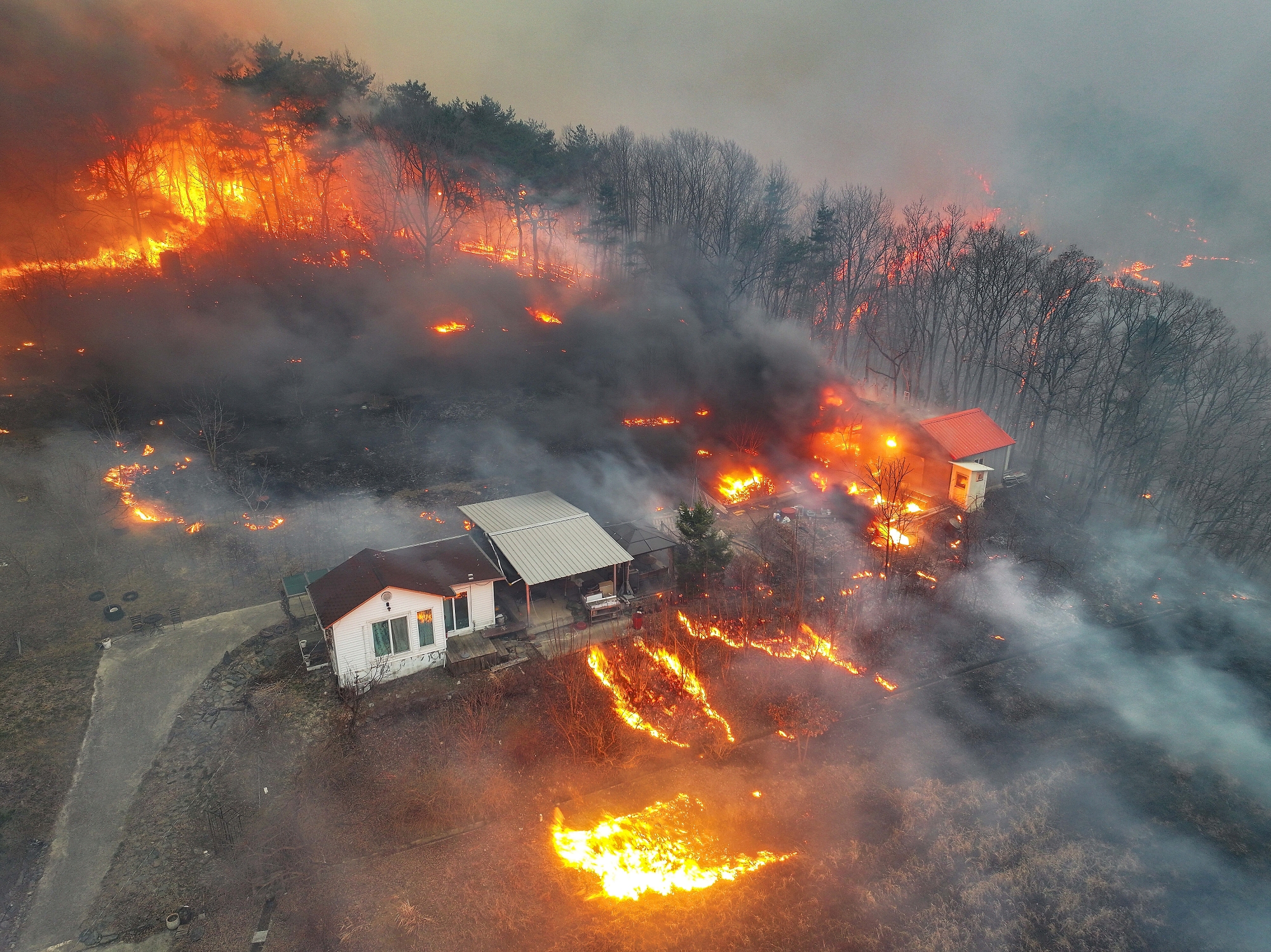 Houses burn in a village after being engulfed by a wildfire fueled by strong winds in Uiseong, South Korea, Monday, March 24, 2025.