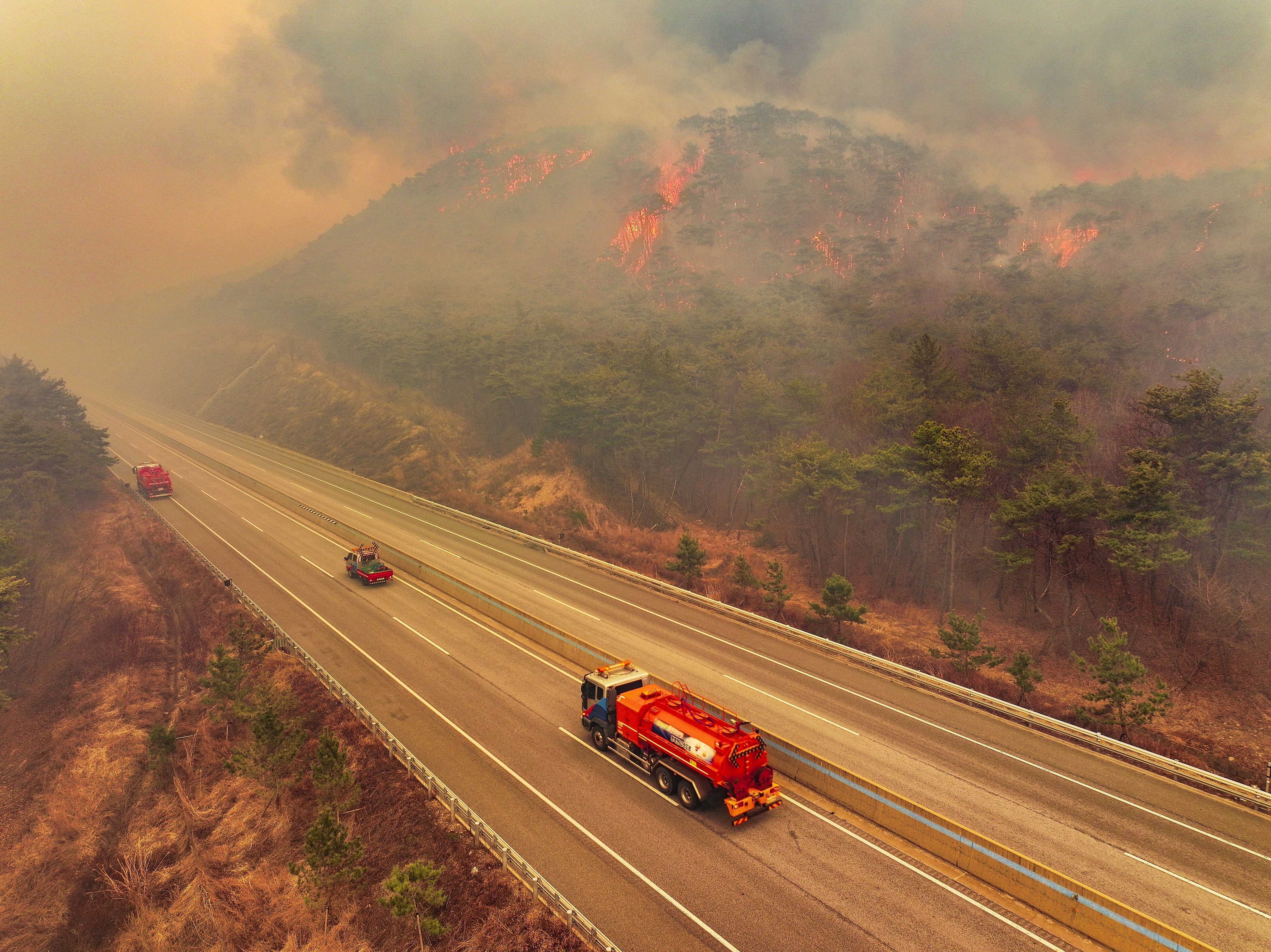 A road is closed as a wildfire fueled by strong winds spreads in Uiseong, South Korea, Monday, March 24, 2025.