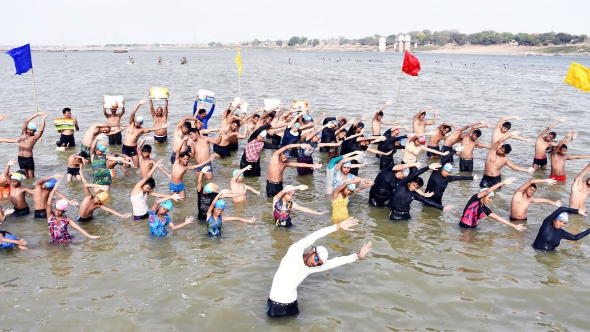 Swimmers perform yoga in Yamuna in Prayagraj on June 19
