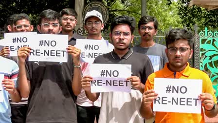 Students hold placards as they stage a protest against the re-examination of the NEET-UG exams, in Rajkot