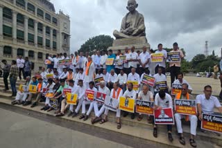 BJP leaders protesting beneath the Gandhi statue in Vidhana Soudha