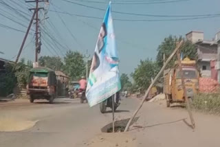 ysrcp_flag_in_road_pothole