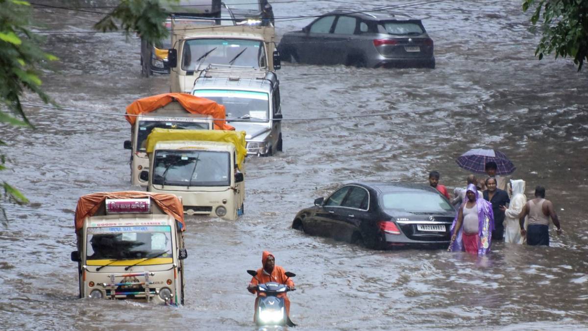 Vehicles wade through a waterlogged road in Kolkata after Dana-induced heavy rainfall