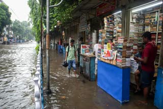 A man wades through a waterlogged street in Kolkata