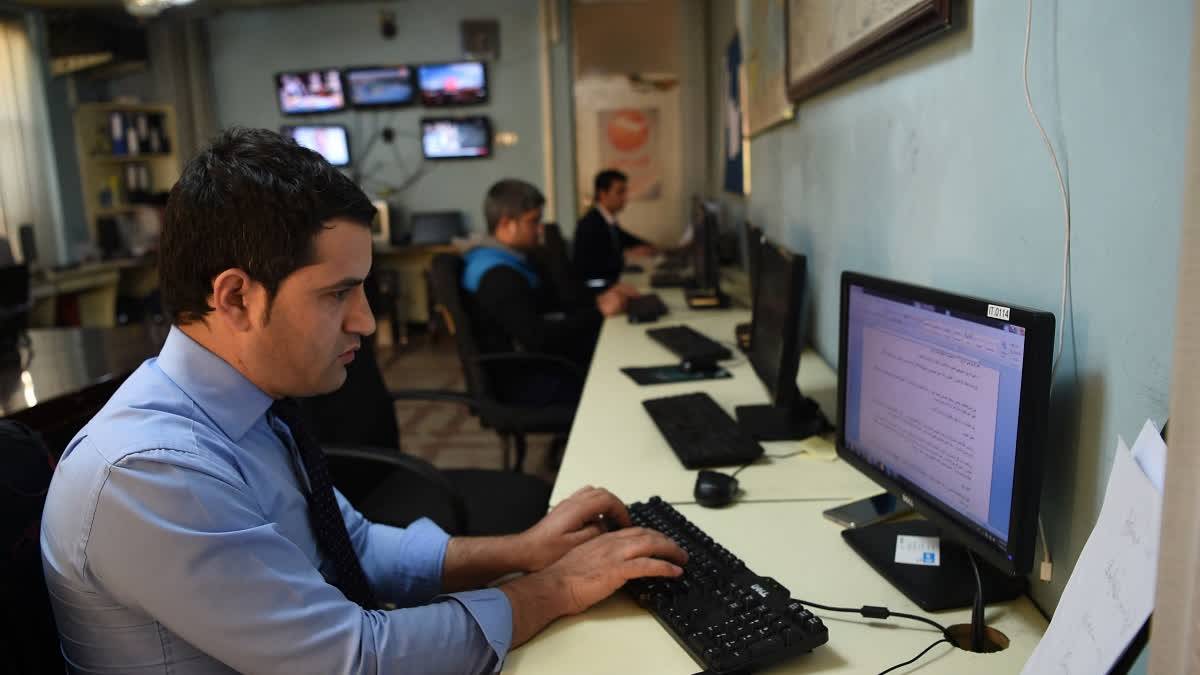 In this photo taken on April 4, 2019 Afghan reporters work in the newsroom at the Khurshid TV station in Kabul.