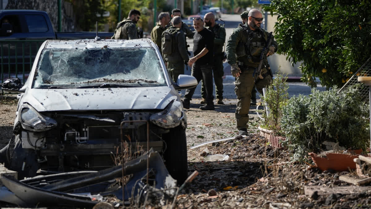 Israeli security officers and army soldiers inspect the site where a rocket fired from Lebanon landed in a backyard in Kiryat Shmona, northern Israel, Tuesday Nov. 26, 2024.