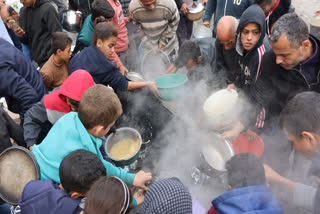 Palestinians queue to receive a food ration outside a distribution center west of Gaza City, on November 25, 2024, amid the ongoing conflict between Israel and the militant Hamas group.