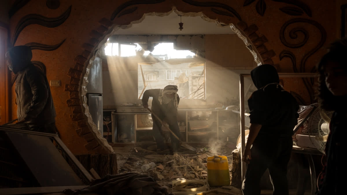 Palestinians look at their neighbour's damaged house following an Israeli strike in Rafah, southern Gaza Strip, Saturday, Jan. 27, 2024. (AP Photo/Fatima Shbair)