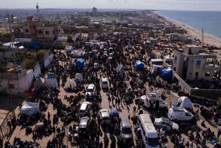 An aerial photograph taken by a drone shows displaced Palestinians gathering with their belongings near a roadblock on the al Rashid Street, as they wait to return to their homes in the northern part of the Gaza Strip, Sunday, Jan. 26, 2025, days after the ceasefire deal between Israel and Hamas came into effect.