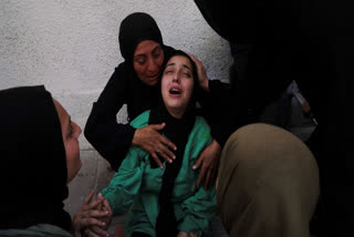 Walaa Al-Kilani, center, mourns her mother and brother, who were killed when an Israeli military strike hit a school sheltering displaced residents, at Al-Shifa Hospital in Gaza City, Monday, May 26, 2025.