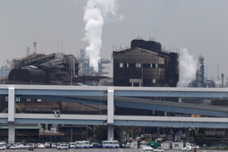 FILE - Smoke billows from an oil refinery in Kawasaki, southwest of Tokyo, on Oct. 21, 2013.