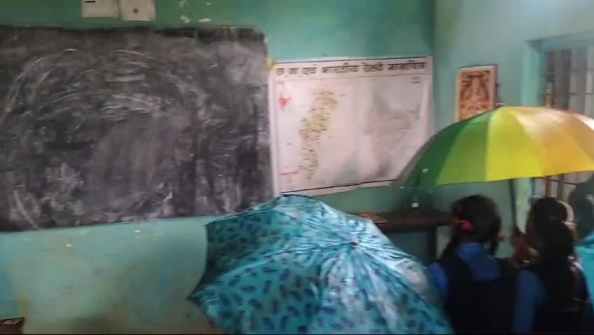 Children studying in class with umbrellas