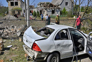 People walk in front of their damaged houses after Russian rocket attack in Usatove village near Odesa, Ukraine, Monday, Aug. 26, 2024.