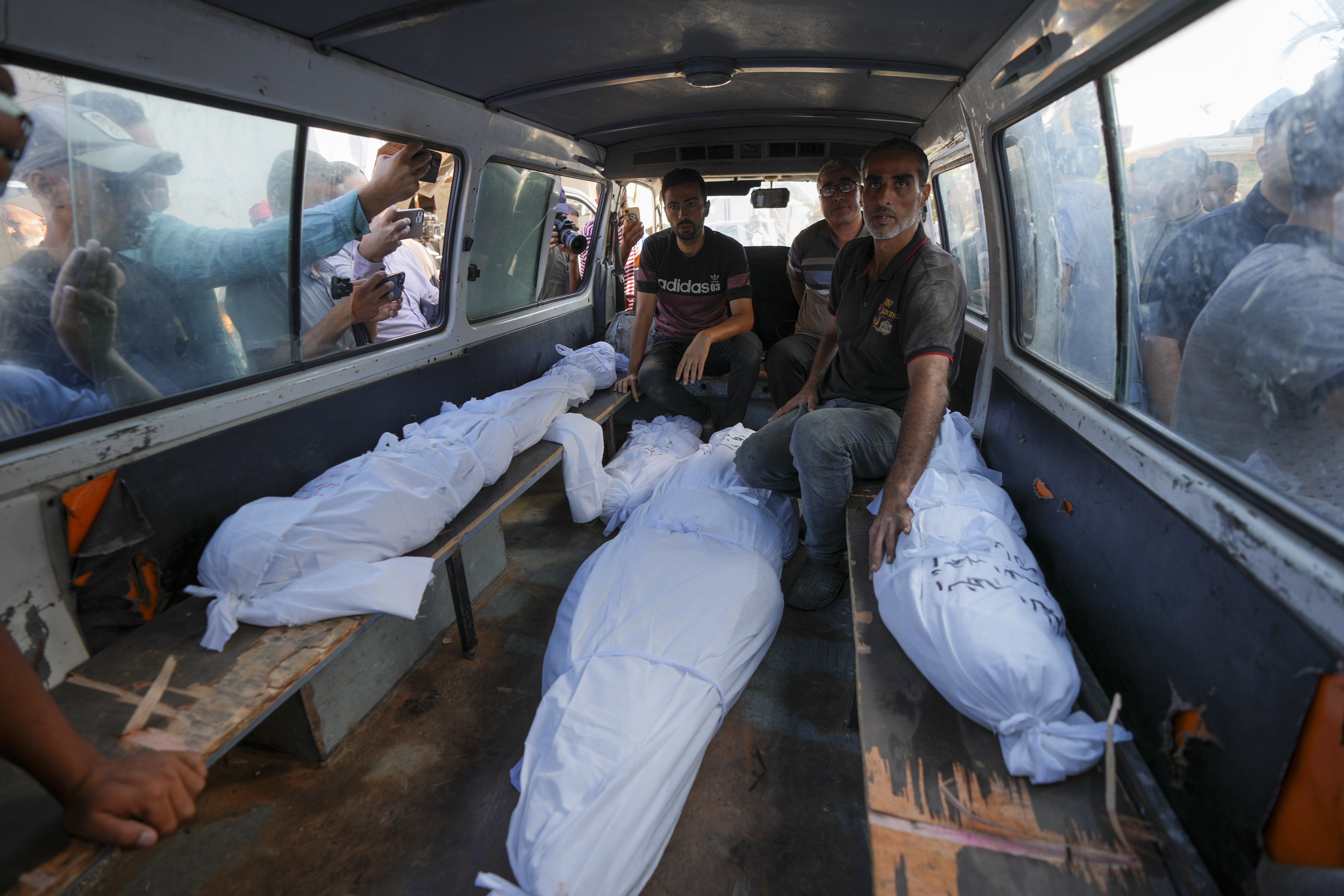 Mourners transport the bodies of their relatives killed in the Israeli bombardment of the Gaza Strip during their funeral in Deir al-Balah