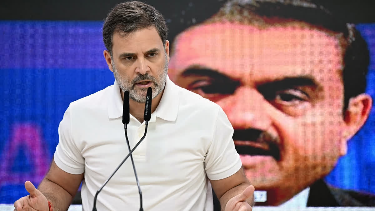 India's Congress party leader Rahul Gandhi addresses a press conference against the backdrop of a picture of Indian industrialist Gautam Adani, at his party headquarters in New Delhi on November 21, 2024.