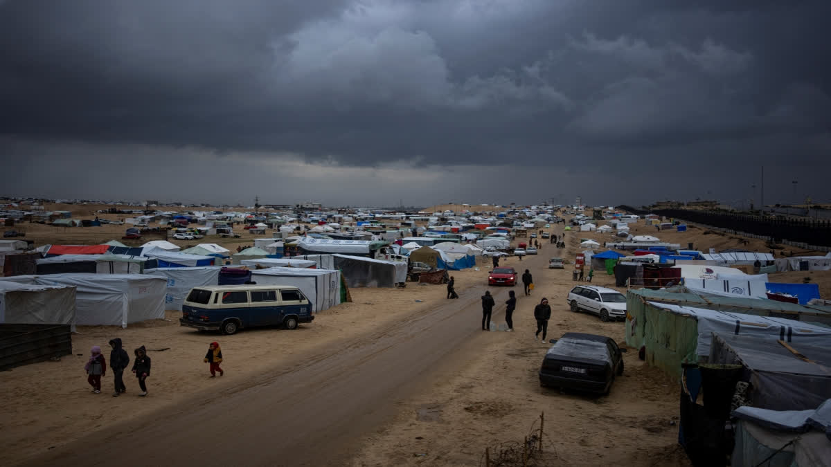 Palestinians displaced by the Israeli air and ground offensive on the Gaza Strip walk through a makeshift tent camp in Rafah on Saturday, Jan. 27, 2024. (AP Photo/Fatima Shbair)