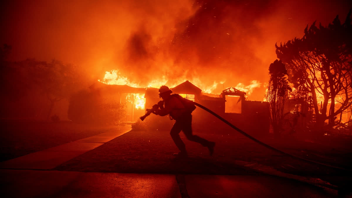 FILE - A firefighter battles the Palisades Fire as it burns a structure in the Pacific Palisades neighborhood of Los Angeles, Jan. 7, 2025.