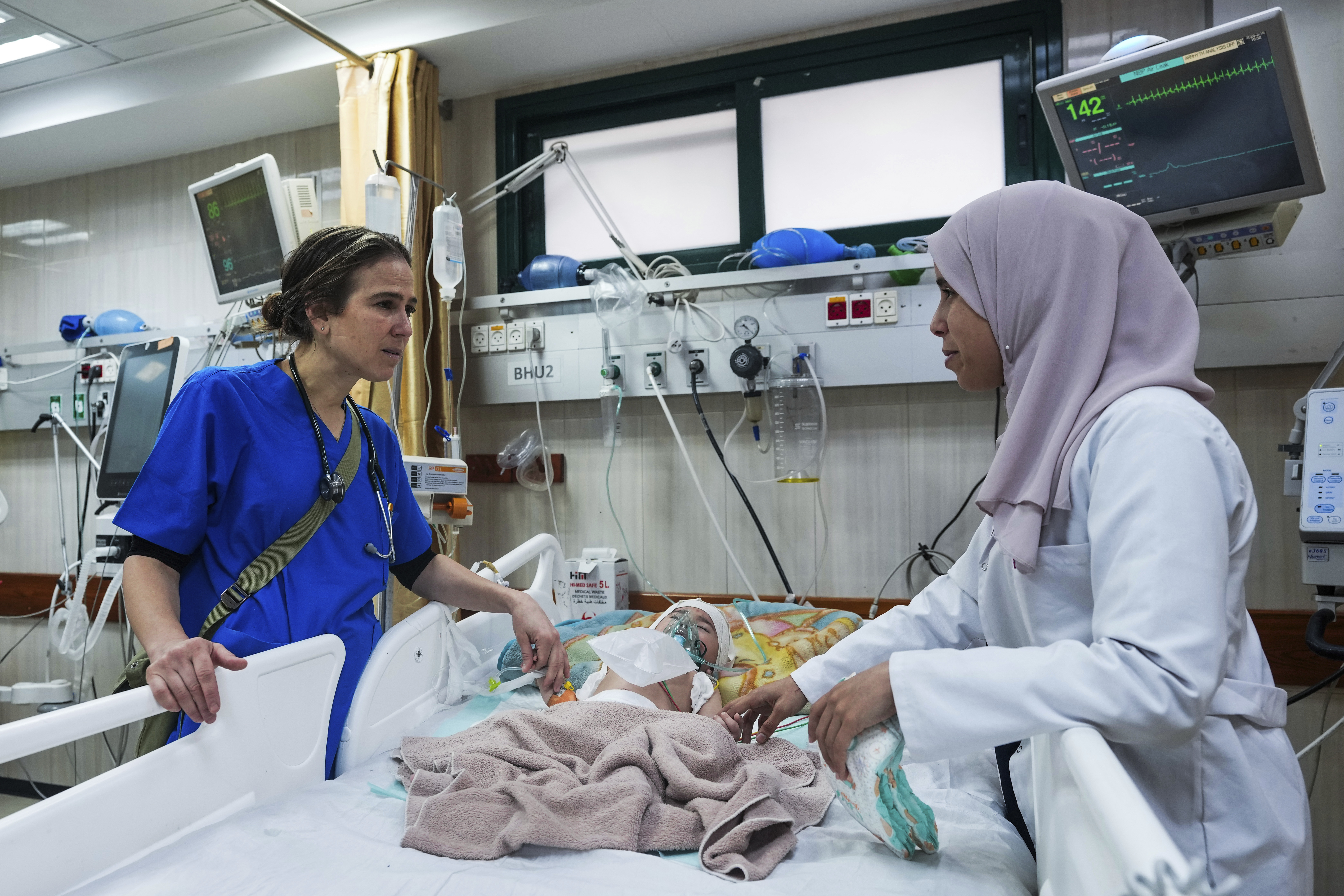 ماہر اطفال تانیا حج حسن، دیر البلاح کے الاقصی شہداء ہسپتال میں غزہ کے زخمی بچوں کا معائنہ کر رہی ہی۔۔۔۔۔۔۔ (Photo: AP)
