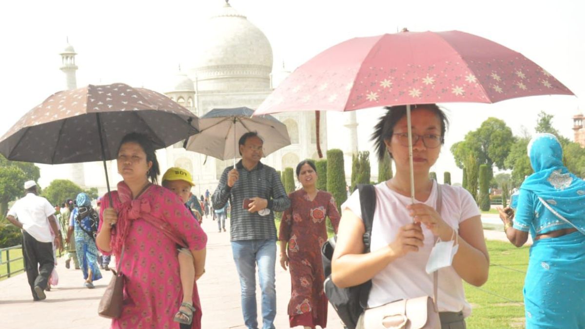 Tourists are using umbrellas to save themselves from heat in Taj Mahal