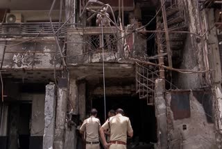 Police personnel inspect the New Born Baby Care Hospital site where a fire incident took place on May 25th, claiming the lives of six newborn babies and injuring several others, in New Delhi on Monday, May 27, 2024.