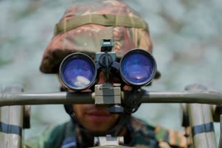 An Indian army soldier keeps a vigil from one of the forward posts along the line of control between India and Pakistan during a media tour somewhere in north Kashmir.