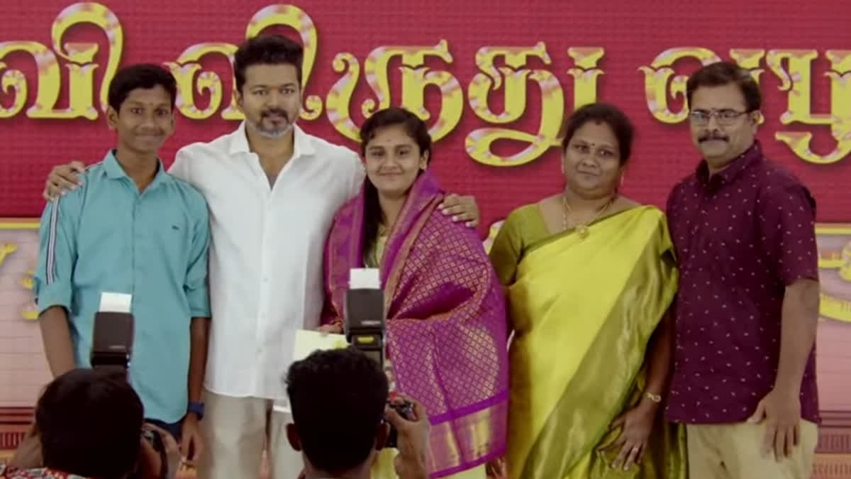 Thalapathy Vijay poses with a topper in second annual 'Education Award Ceremony' held by Tamilaga Vettri Kazhagam