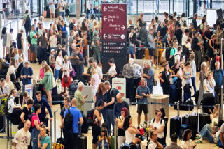 Passengers wait in front of check-in counters at the capital's Berlin Brandenburg Airport, in Schönefeld, Germany, Friday, July 19, 2024, after a widespread technology outage disrupted flights, banks, media outlets and companies around the world.