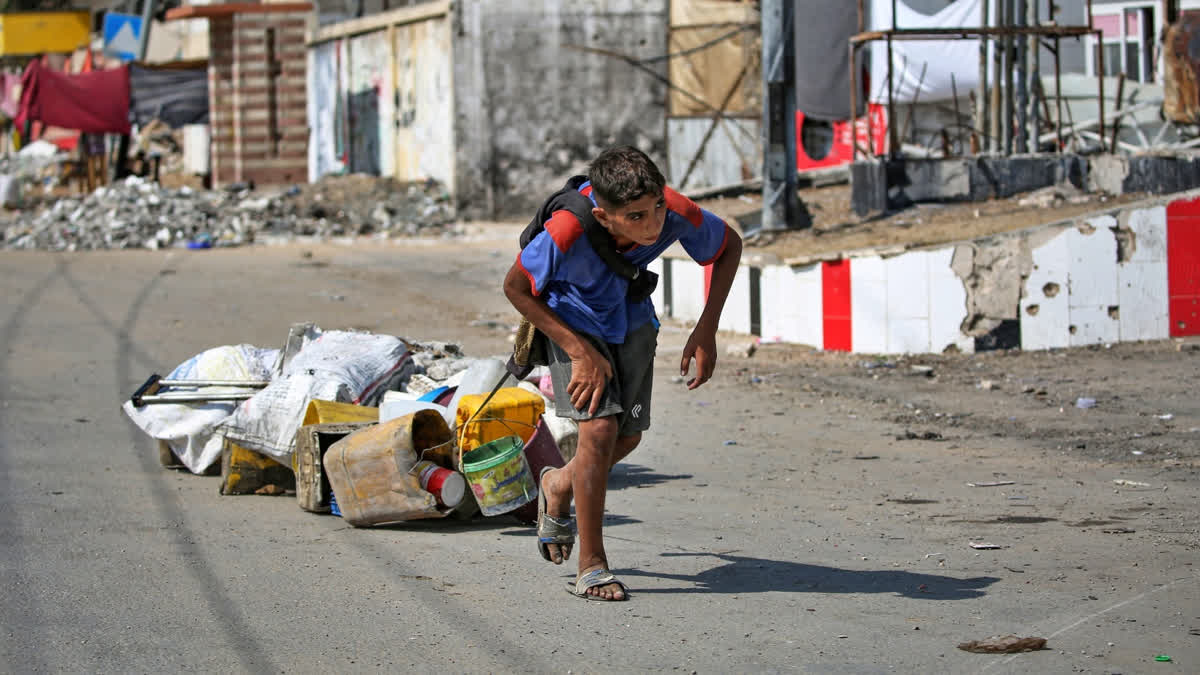 A Palestinian boy pulls salvaged items in Deir al-Balah in the central Gaza Strip on August 27, 2024, amid the ongoing war between Israel and the Palestinian Hamas movement.