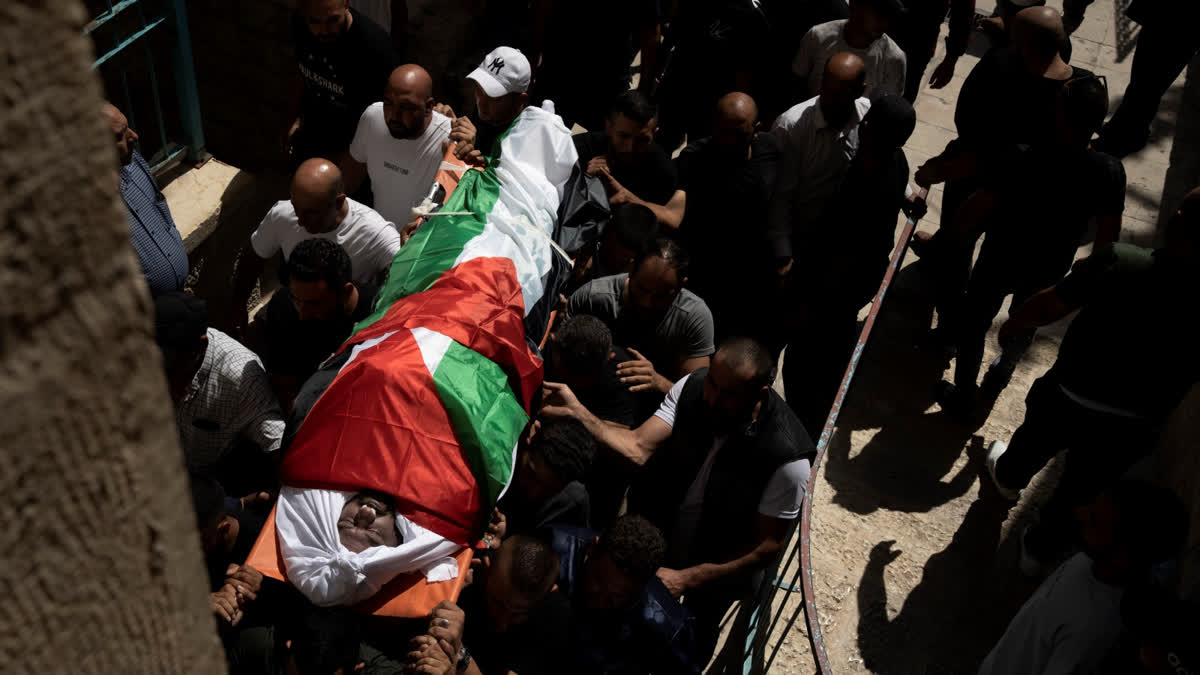 Mourners carry the body of Khalil Ziada, wrapped in a Palestinian flag, as they leave a hospital morgue during his funeral in the West Bank city of Bethlehem, Tuesday, Aug. 27, 2024. He died in an Israeli settler attack in Wadi Rahal village.