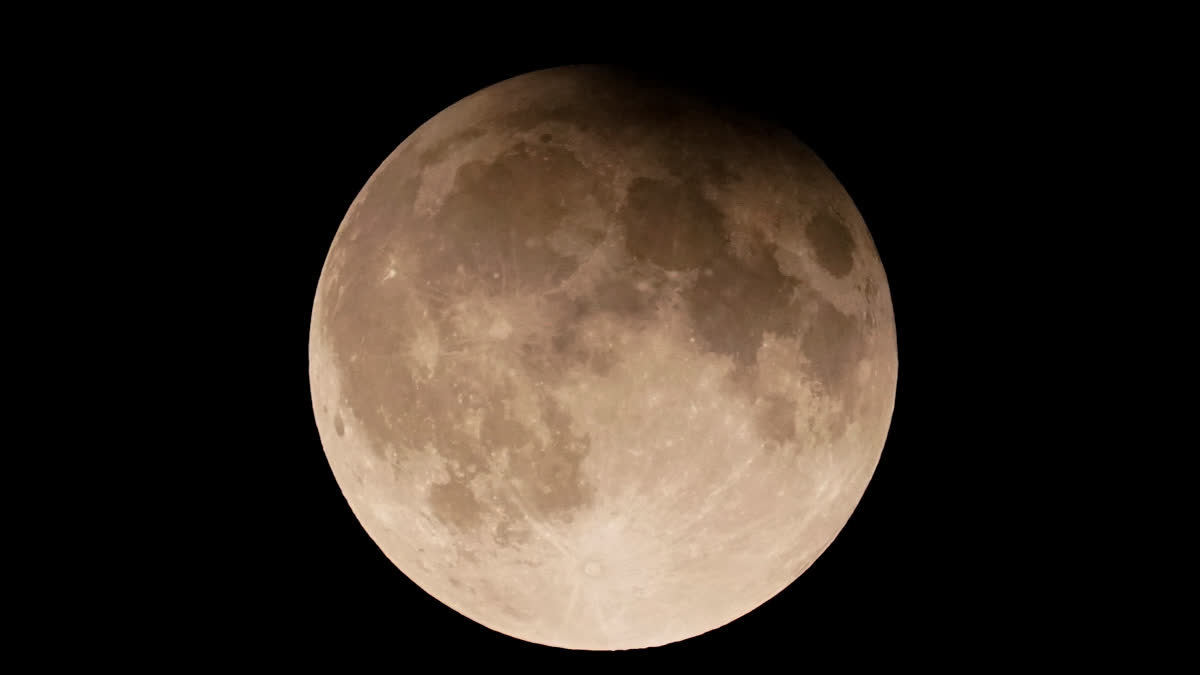 FILE - A supermoon with a partial lunar eclipse rises over Lake Michigan in Chicago, Tuesday, Sept. 17, 2024.