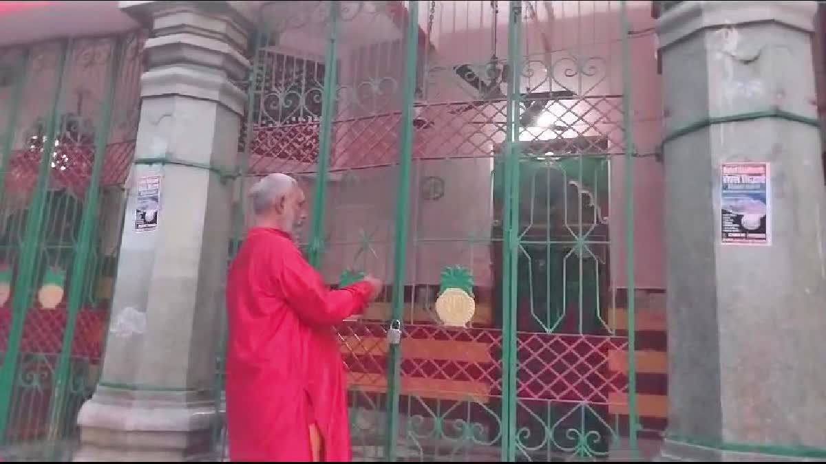 मंदिर के कपाट बंद करते पुजारी