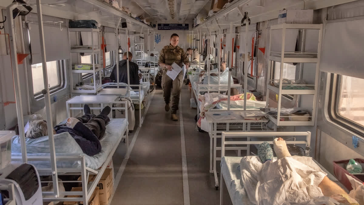 Olena, a military medic, checks on injured Ukrainian soldiers on a military evacuation train transporting Ukrainian servicemen wounded in frontline areas to hospitals, in an undisclosed location, on October 18, 2024, amid the Russian invasion of Ukraine.