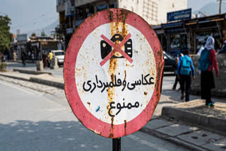 A signboard with the warning 'Photography and Video recording forbidden' is displayed along a street in Kabul on October 22, 2024.