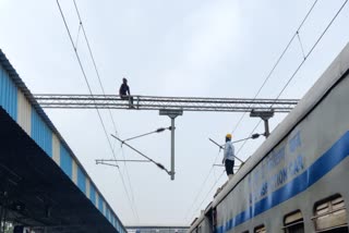 person climbing railway pole